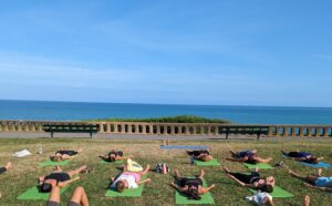 groupe de personnes qui font du yoga face à l'océan à Biarritz