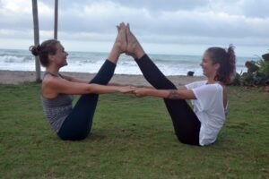 deux femmes qui font du yoga ensemble près de la mer